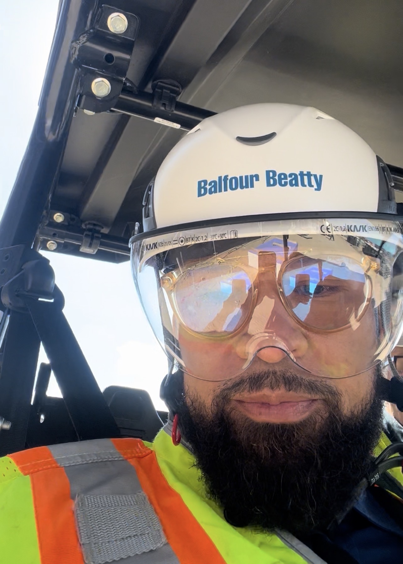 Dr. Martinez in the field wearing a hard hat, protective glasses, and high-visibility vest