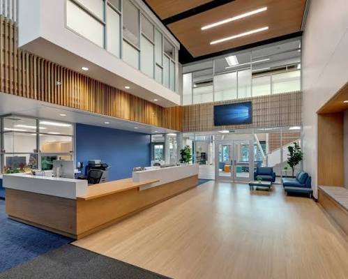 Reception area with wood finishes, seating, and a two-story ceiling at Sonia Sotomayor Elementary School