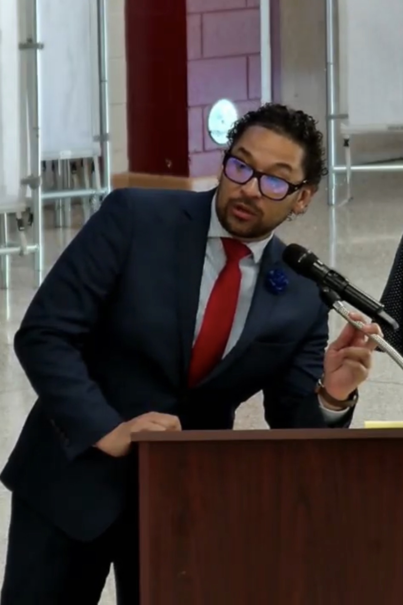 Dr. Martinez addressing the school board at a lectern